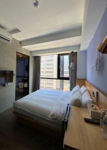 1 dormitorio con 1 cama grande y ventana grande en Just Inn Xin Yi 正旅館 信義, en Taipéi