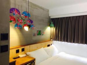 a bedroom with a bed and a table with a bed sidx sidx sidx at Just Inn Xin Yi 正旅館 信義 in Taipei