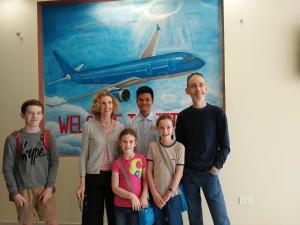 a family posing in front of a painting of an airplane at Family Airport Hotel - 5 minutes Noi Bai in Noi Bai