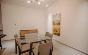 een eetkamer met een tafel en stoelen en een schilderij bij Big chill stays in Madina