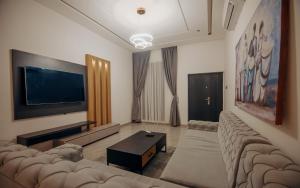 een woonkamer met banken en een flatscreen-tv bij Big chill stays in Madina