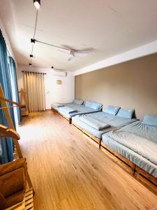 3 camas en una habitación grande con suelo de madera en Ostrich homestay - Venue Travel, en Ba Vì