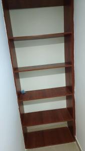 a book shelf with wooden shelves in a room at Edificio El Trébol in Bogotá