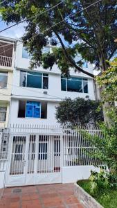 a white house with a white fence in front of it at Edificio El Trébol in Bogotá