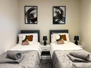 twee bedden naast elkaar in een slaapkamer bij Central Semi - Detached Home with Private Parking! in Buckinghamshire