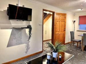 een woonkamer met een flatscreen-tv aan de muur bij Central Semi - Detached Home with Private Parking! in Buckinghamshire