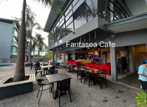 a cafe with tables and chairs in front of a building at D' Palm Garden Homestay Lahad Datu. in Lahad Datu