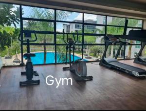 a gym with cardio equipment and a swimming pool at D' Palm Garden Homestay Lahad Datu. in Lahad Datu