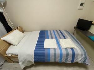 a bed in a room with two towels on it at ホワイトテラス桜新町 in Tokyo