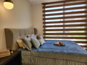 1 dormitorio con cama con almohadas y ventana en Lujo, mar, seguridad y diversión en la mejor zona de Manta., en Manta