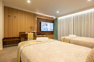 une chambre d'hôtel avec deux lits et une télévision dans l'établissement Alpine Studio Coulson, à Lac Tekapo 4 autres photos