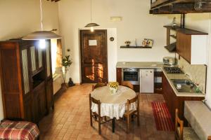 una cucina con tavolo e sedie e una cucina con piano cottura di Country House La Fattoria Di Paolo a Treia