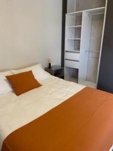 1 dormitorio con 1 cama grande con almohada naranja en TERRAZAS DEL TAFI en Tafí del Valle