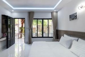 a bedroom with a large bed and a large window at Coastal Village Phu Quoc in Phú Quốc