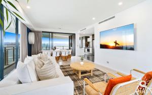 sala de estar con sofá blanco y mesa en The Wave - QStay en Gold Coast