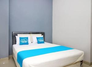 a bed with blue and white pillows on it at Ambon Residence Syariah in Ambon