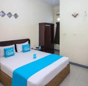 a bedroom with a large bed with blue pillows at Ambon Residence Syariah in Ambon