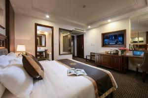 a hotel room with a bed with two books on it at Rex Hanoi Hotel in Hanoi