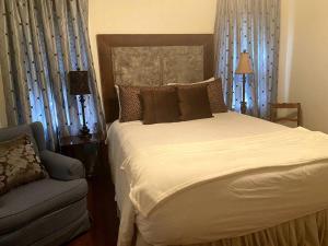 um quarto com uma cama grande e uma cadeira em I40 Large Tuscany 4 bed 20min PDC em Amarillo