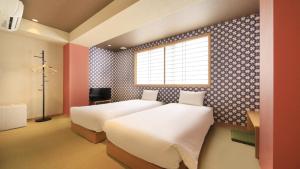 a bedroom with two beds and a window at Asakusa Hotel Hatago in Tokyo