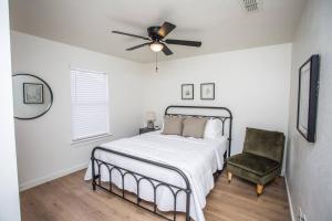 a bedroom with a bed and a fan and a chair at 7 beds Relax by Texas Tech & Hospitals Sleeps 10 in Lubbock