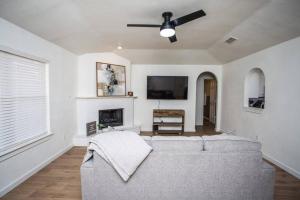 a living room with a couch and a flat screen tv at 7 beds Relax by Texas Tech & Hospitals Sleeps 10 in Lubbock