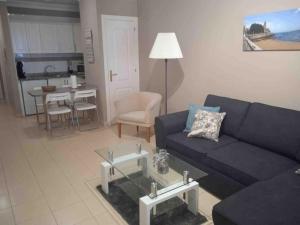uma sala de estar com um sofá azul e uma mesa em Magnifico y acogedor apartamento, zona privilegiada vistas al mar em Puerto de la Cruz