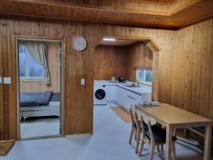 eine Küche mit Holzwänden, einem Tisch und einem Bett in der Unterkunft Amy House in Jeju-do