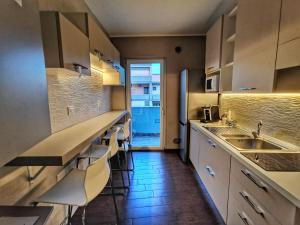 a kitchen with a counter and a sink and chairs at Suite 5 Monopoli in Monopoli