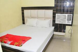 a bedroom with a white bed with a red blanket on it at Goroomgo Dev Guest House Howrah, Kolkata in Hāora