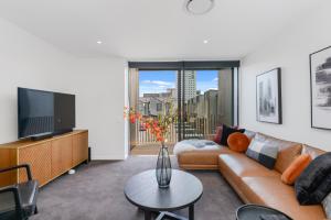 a living room with a couch and a tv at Latimer View Apartment in Christchurch