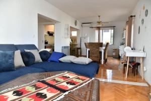 un soggiorno con divano blu e tavolo di Apartments Val - 300 m to the beach a Supetar (San Pietro di Brazza)
