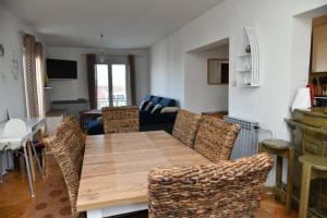 uma sala de estar com uma mesa de madeira e cadeiras em Apartments Val - 300 m to the beach em Supetar