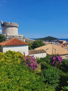 un edificio con una torre sobre algunas plantas en Rooms Garden - with a view, en Dubrovnik
