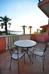 einen Tisch und Stühle auf einem Balkon mit einem Tisch in der Unterkunft Apartments Njoko - sea view in Prvić Šepurine