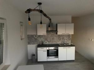 a kitchen with white cabinets and a stove at Apartments Delfin - sea view in Prvić Šepurine