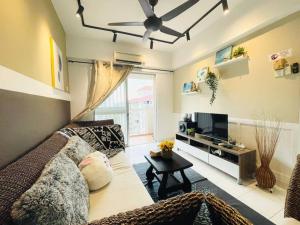 a living room with a couch and a tv at 8 pax Homestay near Axiata Arena & Pavilion 2 in Kuala Lumpur