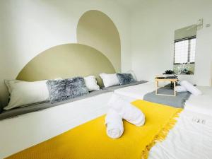 uma sala de estar com duas camas e um tapete amarelo em 8 pax Homestay near Axiata Arena & Pavilion 2 em Kuala Lumpur