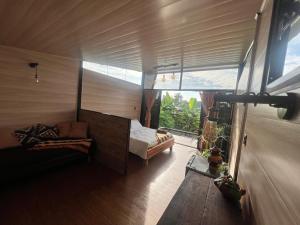 Habitación con cama y ventana grande. en Ruztico glamping, en Villavicencio