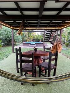 a wooden table and two chairs and a hammock at Ruztico glamping in Villavicencio