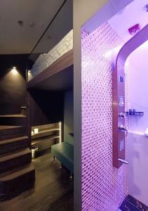um quarto com um beliche com luzes roxas em HOTEL JJH - newly opened near BUGIS em Singapura