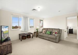 a living room with a couch and a tv at Floreat in Sawtell