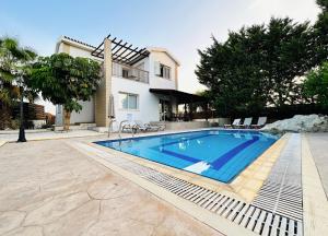 a swimming pool in front of a house at Sunnyside Pool Villa in Ayia Napa