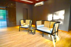 duas cadeiras e uma mesa num quarto em Series Hotel Sudirman em Jakarta