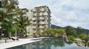 a hotel with a swimming pool in front of a building at By The Sea Batu Ferringhi in Batu Ferringhi