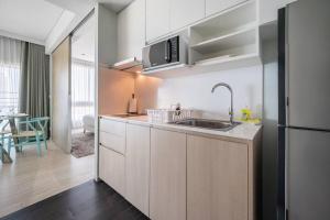a kitchen with a sink and a refrigerator at Veranda Residence/2BRFamilySuite in Na Jomtien