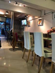 a dining room with white chairs and a table at MOOZ HUAHIN in Hua Hin
