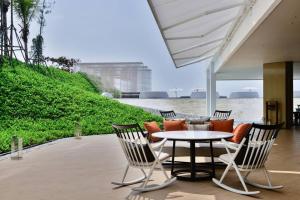 a patio with a table and chairs and the water at Veranda Residence/2BRFamilySuite in Na Jomtien