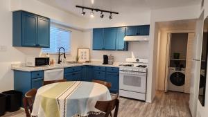 uma cozinha com armários azuis e uma mesa com cadeiras em The Lilly Pad II em Albuquerque
