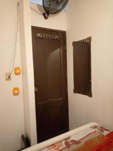 a bathroom with a brown door and a mirror at Acuarela del Rio H#3 Cerca Aeropuerto y Terminal Habitación privada con baño in Guayaquil